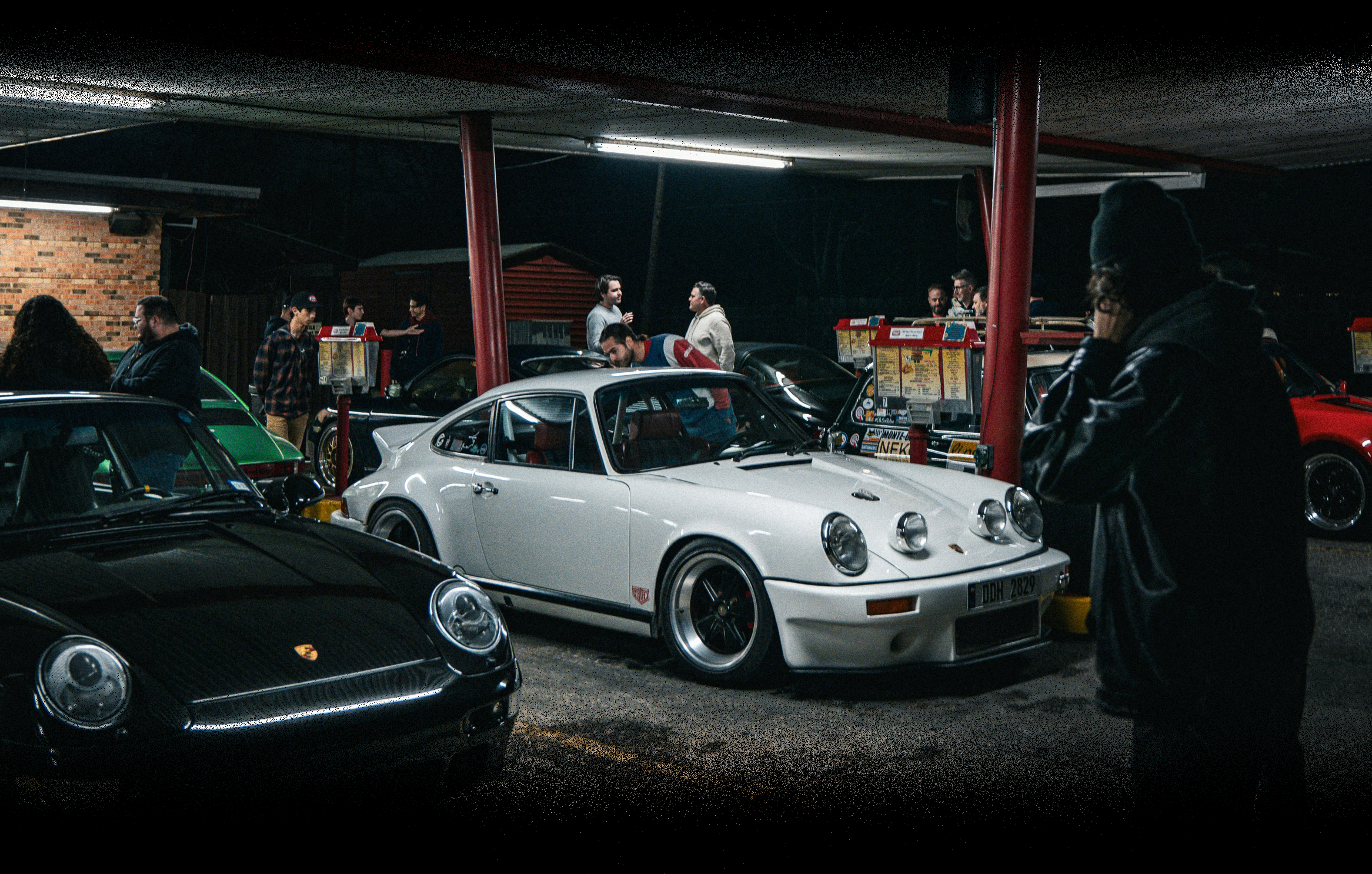 Vintage Porsche cars on display at a car show with people around.